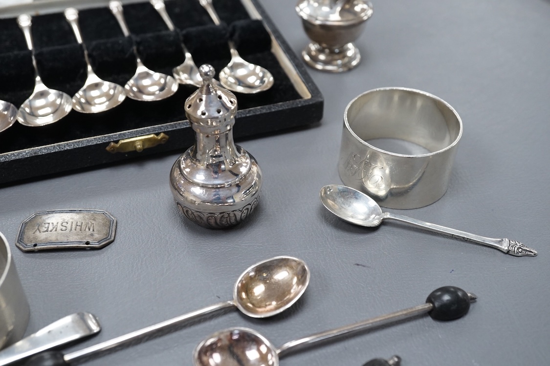 Four assorted silver napkin rings, two cased sets of six silver spoons, four silver condiments including a pair, a small group of sundry flatware, a silver wine label and a plated napkin ring.